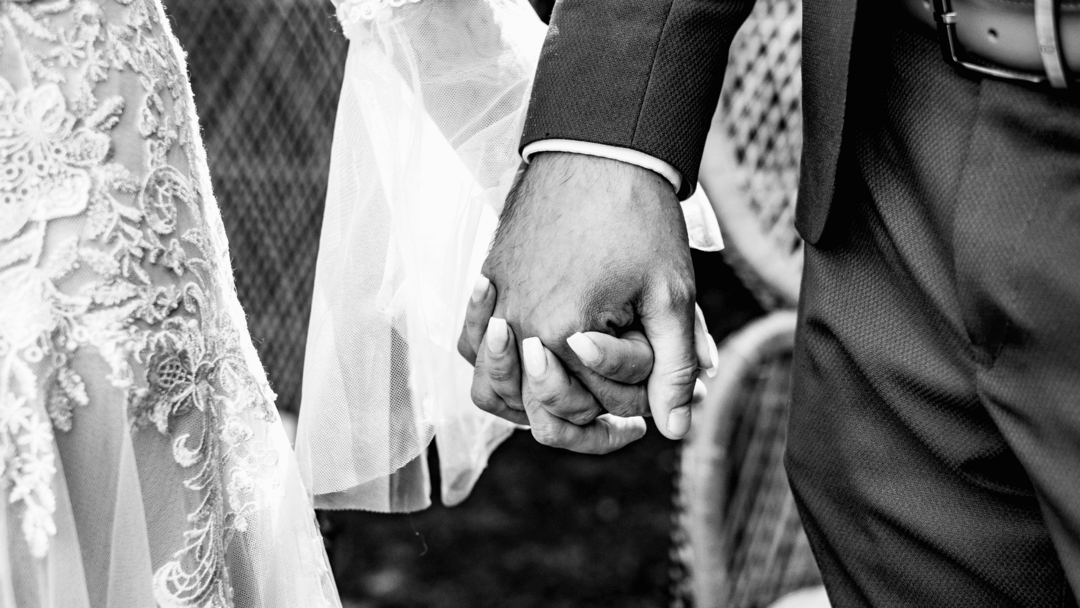Focus sur les mains entrelacés des mariés